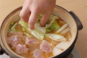鶏肉を入れ、大根、ねぎ、白菜、しめじ、油揚げを加えて煮る。野菜が柔らかくなったらでき上がり。器に取り分け、すりごま、七味唐辛子をふっていただく。