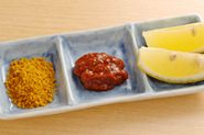 天ぷらには下味がついているので、そのままや、塩だけでもおいしく食べられますが、薬味を変えるとまた違ったおいしさになります。写真は左から、カレー塩（塩にカレー粉を混ぜたもの）、かんずり（新潟県の特産品。赤唐辛子に米麹と塩を混ぜて発酵させた辛味調味料）、レモン。ほかに、粉山椒やゆずこしょうを添えたり、レモンのかわりにかぼすの果汁をふってもいいでしょう。