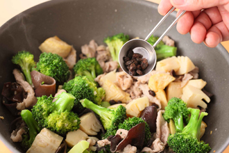 肉の色が変わってきたら、揚げたたけのこ、ブロッコリーを加える。きくらげ、豆鼓、酒、オイスターソースを加え、全体を炒め合わせてできあがり。