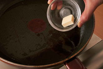 赤ワインソースを作る。フライパンに水大さじ2を入れて中火で煮立たせ、しょうゆ、みりんを加える。ひと煮立ちしたら赤ワインを加え、煮立ったらバターを加える。バターが溶けたら火からおろし、ステーキにかける。