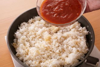 フライパンにご飯を加え、強火で炒め合わせる。玉ねぎが混ざったらミートソースを加え、焦がさないように炒め合わせて塩、黒こしょう各少々で味をととのえて弱火にする。