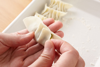餃子の皮に1のひき肉だねをのせ、端を水で濡らして折り畳み、ひだをよせながら包む。残りも同様にする。