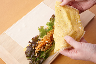 春巻きの皮を置き、手前に半分に切った薄焼き卵をのせ、上にサニーレタス1枚をのせる。2の1/2量と、もう半分の卵焼きをのせてくるくると巻く。残りも同様にしてもう合計2本作る。食べやすく切って皿に盛り、マヨネーズをのせ、上からバターピーナッツを散らす。