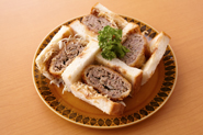 手作りメンチカツとキャベツにソースをかけてサンドイッチにしましょう。パンは食パンを使うのがおすすめ。ジューシーなメンチカツとベストバランスです！