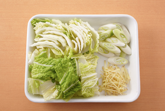 白菜は幅4センチに切り、ねぎは幅1センチの斜め切りにする。しょうがは皮をむかずにせん切りにする。