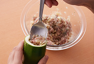 ズッキーニに肉だねを詰める。スプーンで少しずつ入れ、指で押し込みながらすき間なくしっかり詰める。残った肉だねは丸めて団子にする（まとまりにくい場合は、パン粉を加えてつなぎにする）。