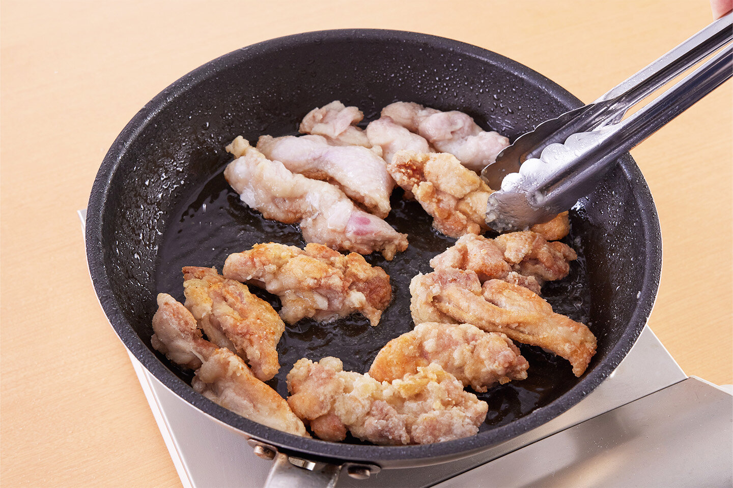 フライパンにサラダ油を入れる。<br>鶏肉を1本ずつ、かるくにぎってから並べ入れる(長いものは半分にたたむとよい)。<br>中火にかけ、7〜8分揚げ焼きにして上下を返し、さらに5分ほど揚げ焼きにし、火を止めていったん取り出す。