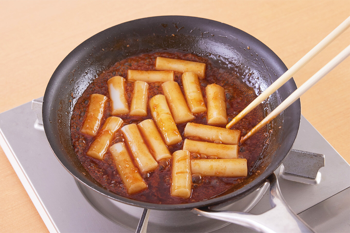 ヤンニョムソースでトッポギも作れます。<br>フライパンにトッポギ(韓国の棒状の餅)150gと水1カップを入れて中火にかけてゆで、やわらかくなったら湯を捨てます。<br>ヤンニョムソースの材料を入れて中火にかけ、トッポギにしっかりからませればでき上がり。