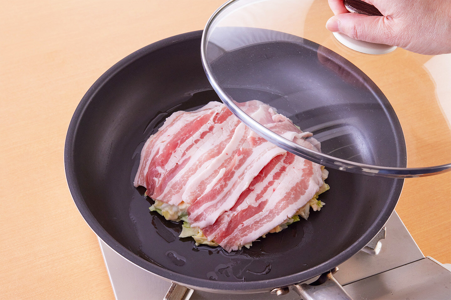 フライパンにサラダ油大さじ1/2を広げて１の生地の半量を丸く広げて入れる。<br>豚肉の半量を広げてのせ、中火にかけ、ふたをして3分蒸し焼きにする。