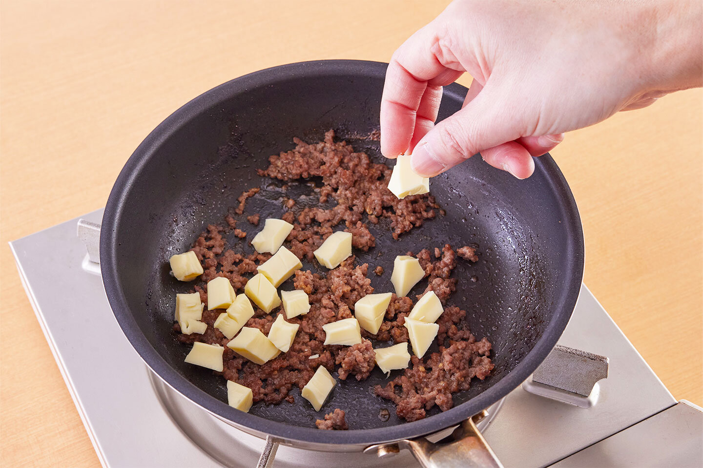 牛肉とチーズのみそそぼろを作る。<br>フライパンにひき肉、みりん、みそを入れて混ぜ合わせ、中火にかける。<br>菜箸でほぐしながら炒め、ひき肉の色が変わったら、プロセスチーズを小さくちぎって加える。一味唐辛子を加えて混ぜ、火を止める。