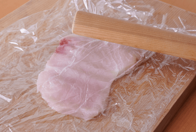 まな板にラップを敷き、かじきをのせて上にもラップをかぶせる。めん棒などでまんべんなくたたいて2倍くらいの大きさに広げ、塩、黒こしょう、薄力粉をまぶす。