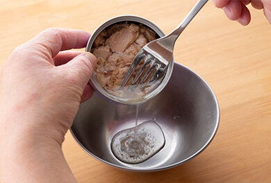 ツナ缶の油（水気）を切る。
